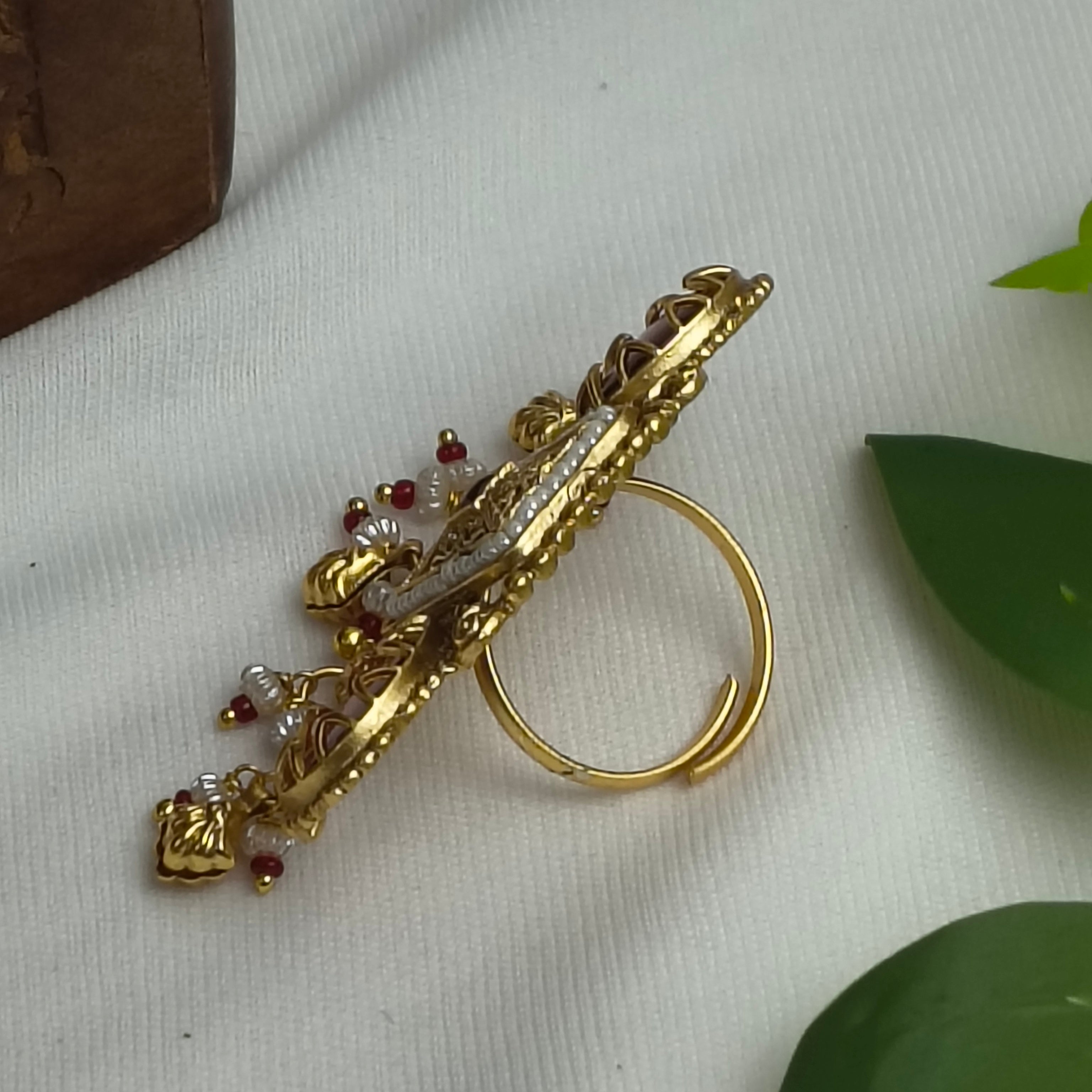Rajasi Antique Gold Kundan Ring with Coral Pink Stones & Pearl Drops, showcasing intricate design and vibrant colors.