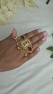 Antique gold kundan ring design featuring red stones and pearl drops, showcasing intricate craftsmanship.